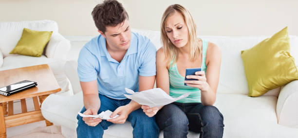 istock Concentrated young couple calculating bills sitting on the sofa 856740672