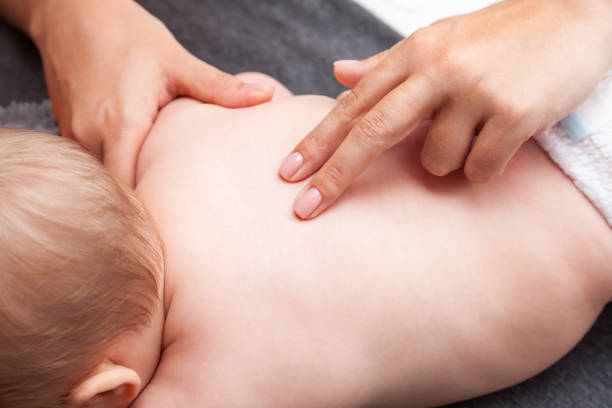 petit bébé recevant un traitement chiropratique de son dos - dos humain photos et images de collection