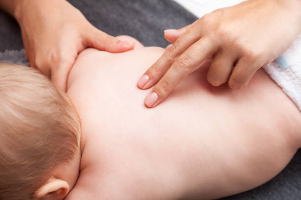 Little baby receiving chiropractic treatment of her back stock photo