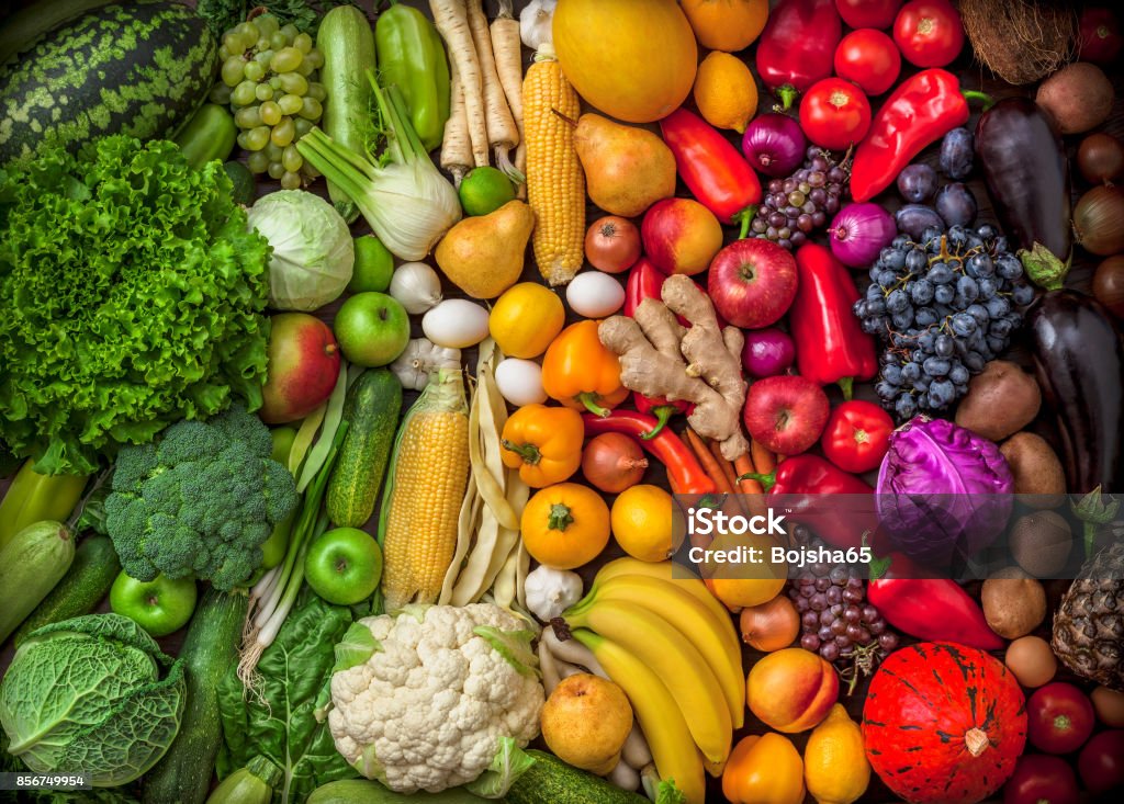 Fruits and vegetables large overhead colorful mix green to red Fruits and vegetables background large overhead colorful mix green to red in studio. Green, white, orange, red. Vegetable Stock Photo