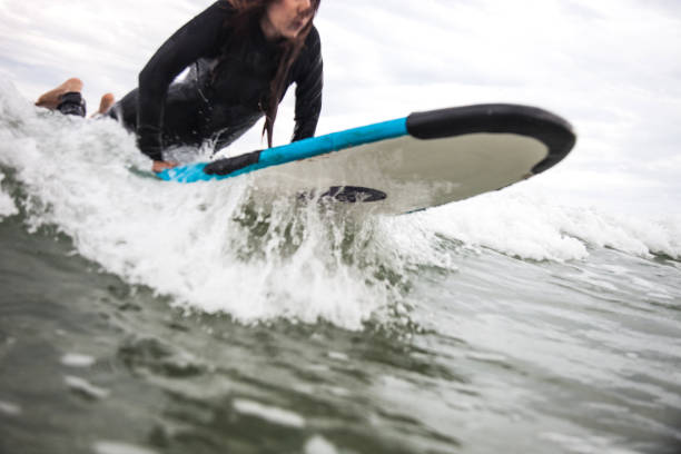 istock Woman on the beach go surfing into the sea waves 856750032