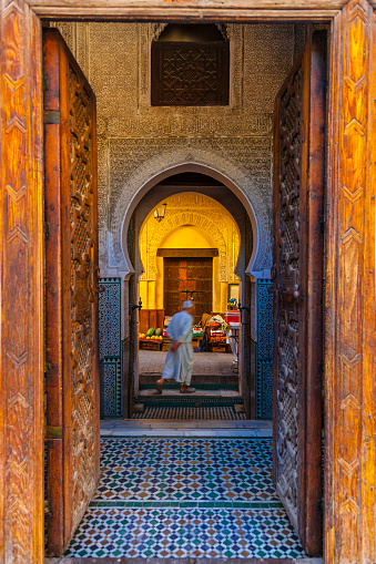 Arabic muslim man in old Medina narrow street of Fes in Morocco  (Madrasa Al-Attarine).
