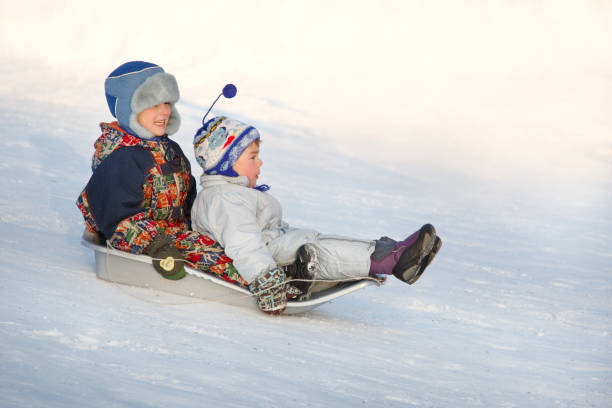 istock Two joyful child sledding down the hills in a winter day. 856754214