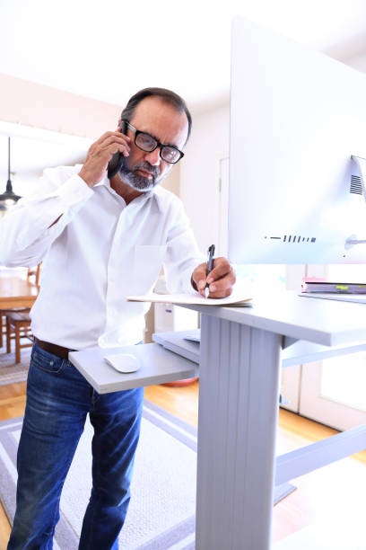 istock Latino Businessman Works At Standing Computer Desk At Home 856760122