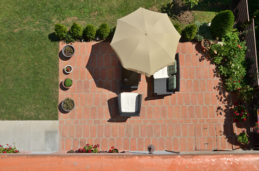 Bird's eye view of garden furniture under parasol surrounded by garden plants