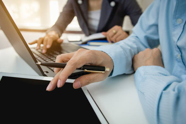 istock Businessman with finger touching screen of a digital tablet at office on table with document graph data, Businesswoman calculate about cost, Finance managers task, Concept finance investment 856780808