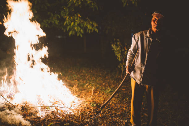 istock Senior man burning grass and leafs in the field 856783086