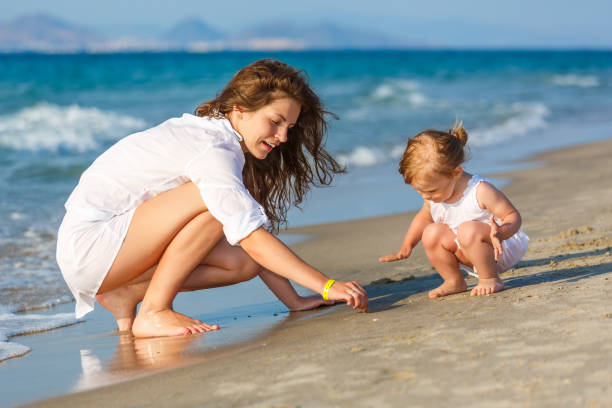 istock Mother and daughter playing on the beach 856783108