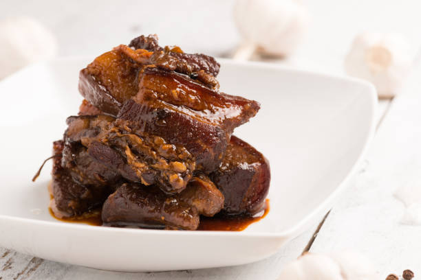 Homemade Braised pork in brown sauce Homemade Braised pork in brown sauce in plate on white wooden background dong stock pictures, royalty-free photos & images