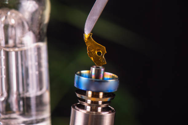 Dabbing tool with small piece of cannabis oil aka shatter - medical marijuana concentrates concept stock photo