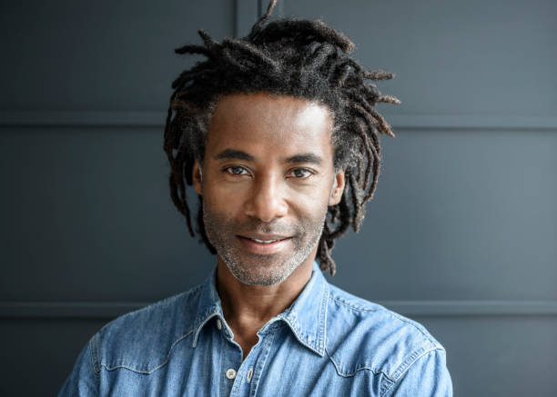 Mature man with dreadlocks looking towards camera and smiling