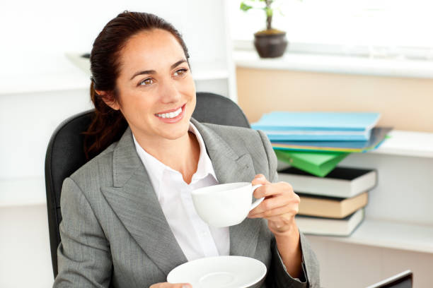 istock Cheerful businesswoman drinking coffee at her desk 856791904