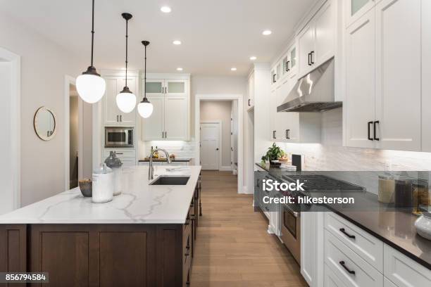 Beautiful Kitchen In New Luxury Home With Island Pendant Lights And Glass Fronted Cabinets Stock Photo - Download Image Now