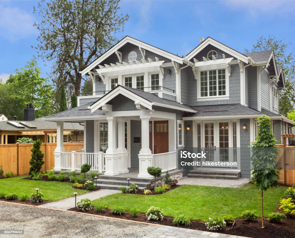 Beautiful Luxury Home Exterior with Green Grass and Landscaped yard new luxury home with elegant touches including covered entrance, columns House Stock Photo