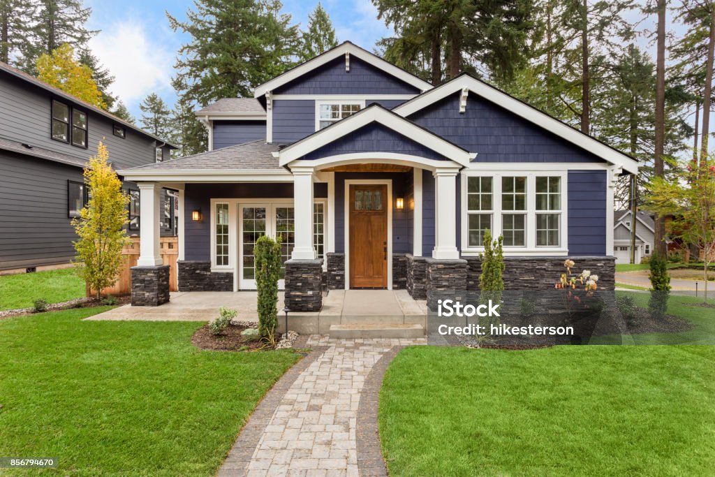 Beautiful Luxury Home Exterior with Green Grass and Landscaped yard new luxury home with elegant touches including covered entrance, columns House Stock Photo