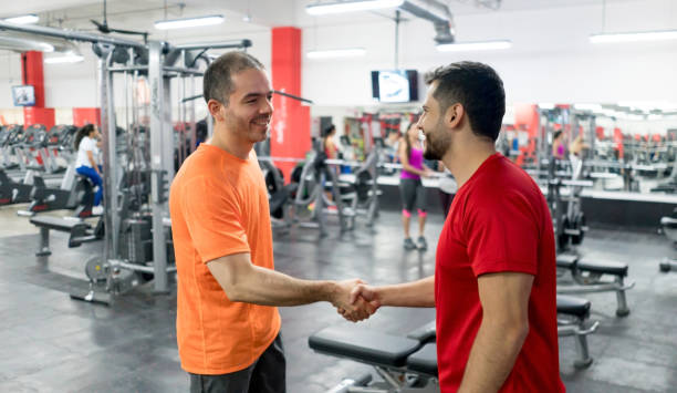 istock Man at the gym greeting his personal trainer with a handshake 856794870
