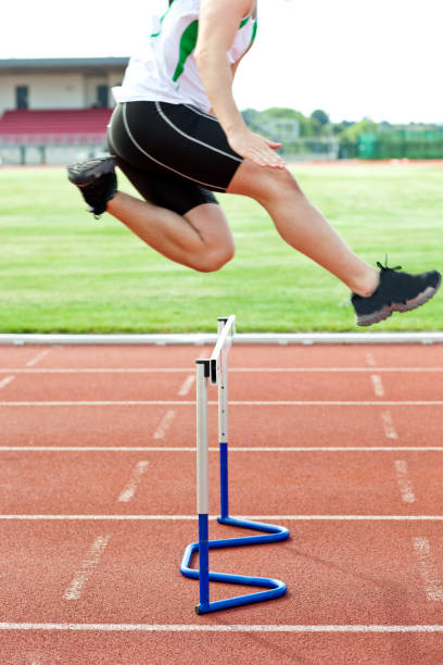 istock Determined male athlete jumping above hedge during a race 856798290