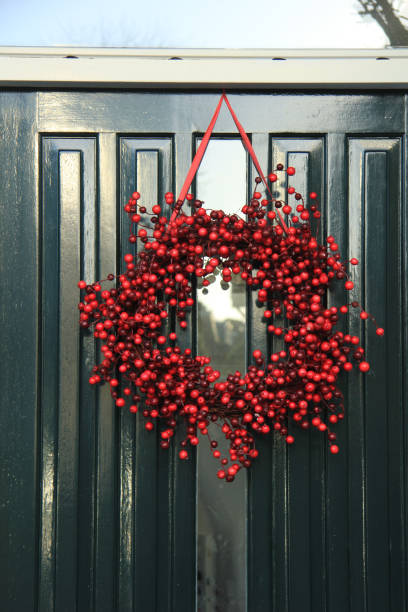 istock Berry christmas wreath with decorations on a door 856804062
