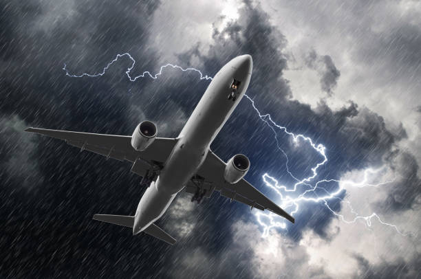 istock White passenger airplane landing during a thunderstorm of rain, bad weather. 856808912