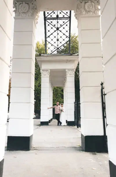 Photo of Romantic couple newlyweds in a beautiful old city park with white marble columns