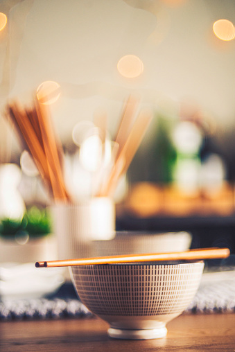 Japanese culture. Rice bowls with chopsticks in defocused bar setting