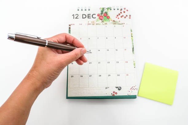 istock isolated close up woman hand note appointment on December calendar 856837660