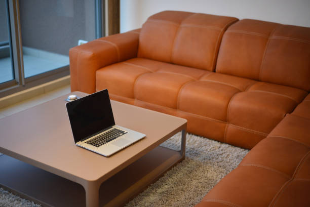istock Laptop on table in modern living room with blank screen 856838350