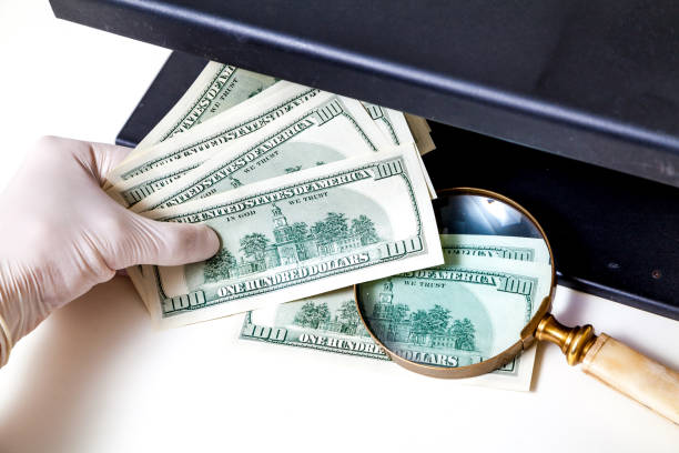 istock Hands in gloves check dollar bills on detector 856839844