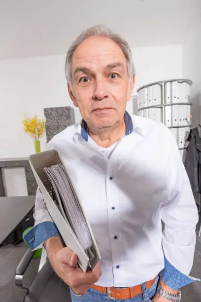 elderly man with a white shirt hands over a file folder