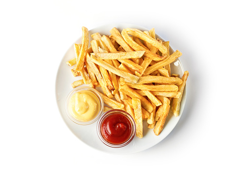 French fries on white plate with ketchup and cheese sauce isolated on white background. Top view.