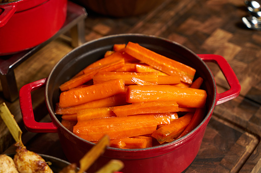Boiled carrots. Delicious fresh vegetable carrots in the cooking pan on the kitchen table. Healthy vegetarian diet food concept. Closeup