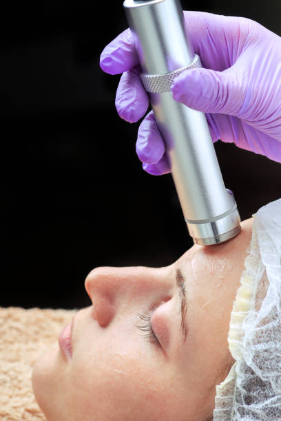 istock Needle dermatology. Beautician performs a needle dermatology treatment on a woman's face 856858256