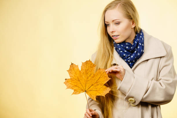istock Woman holding orange autumn leaf 856869980