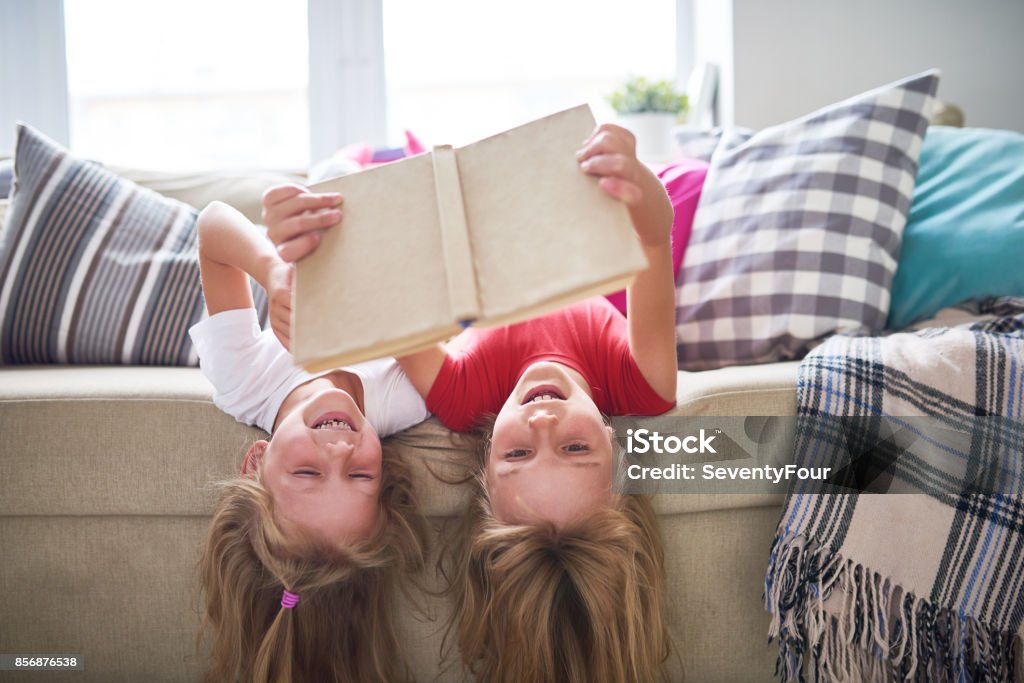 Schwestern Buch auf den Kopf gestellt - Lizenzfrei Familie mit zwei Kindern Stock-Foto