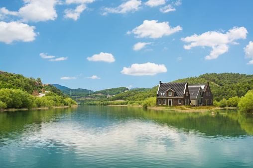 The lakeside house and fresh green nature with blue sky.