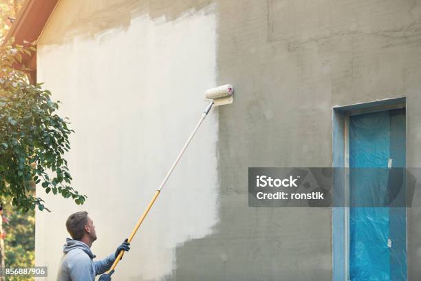 House Painter Painting Building Exterior With Roller Stock Photo - Download Image Now