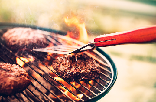 Tasty meat on the grill outdoors, preparing barbecue pork for burgers, traditional summer food cookout, good food for party outdoor