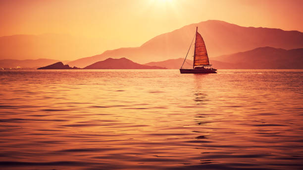 istock Sailboat in beautiful mild orange sunset light 856889084