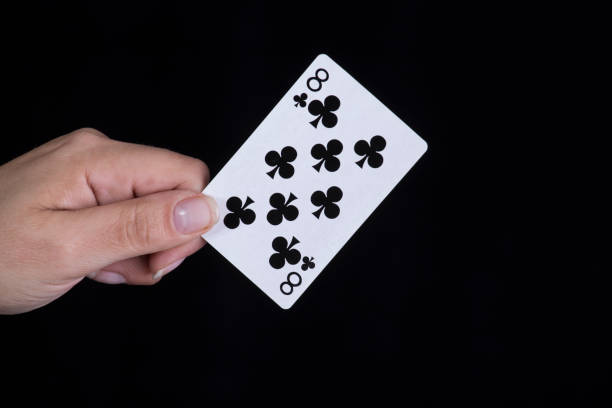 Hand holds a eight of clubs card