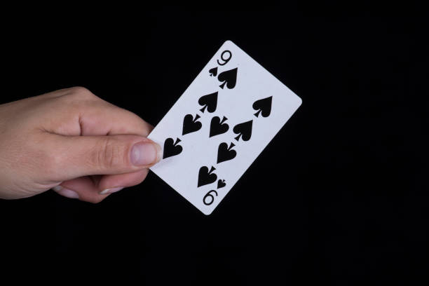 istock Hand holds a nine of spades card 856901156