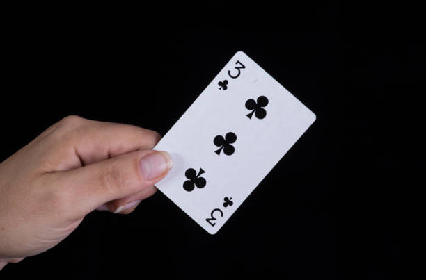 istock Hand holds a three of clubs card 856908306