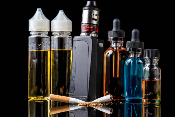 istock Electronic cigarette with e-juice bottles versus old tobacco cigarette 856908568