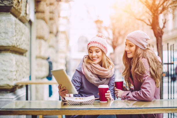 jeunes femmes s’amusent dans un coffee shop - ipad shopping gift retail photos et images de collection