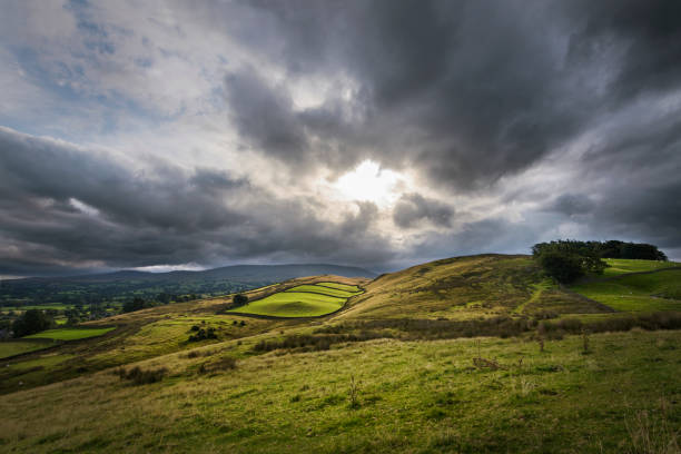 istock Sun breaks through clouds and shines on rural farmland England 856912304