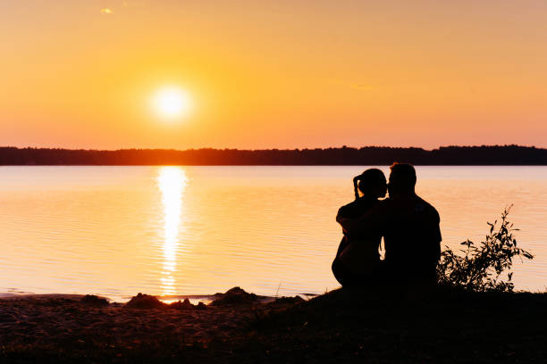 istock Romantic couple on the beach at colorful sunset on background 856913002