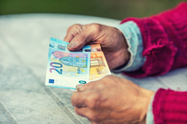 istock Pensioner man holding in hands euro banknotes 856923326