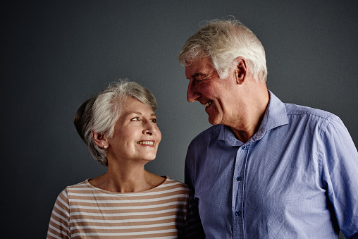 Studio shot of an affectionate senior couple posing against a grey background