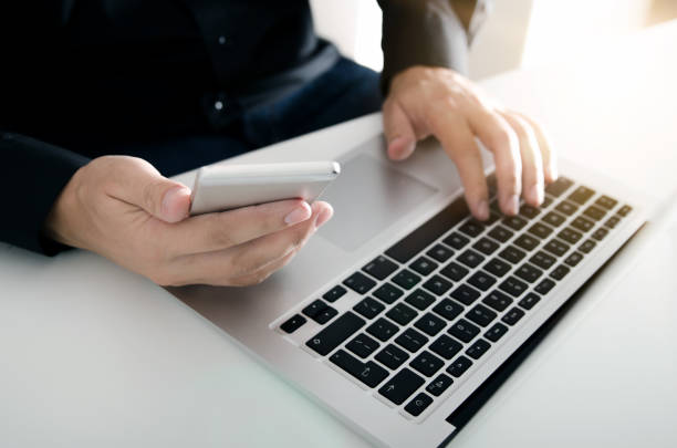 istock A man in a black shirt using mobile phone and laptop 856924298