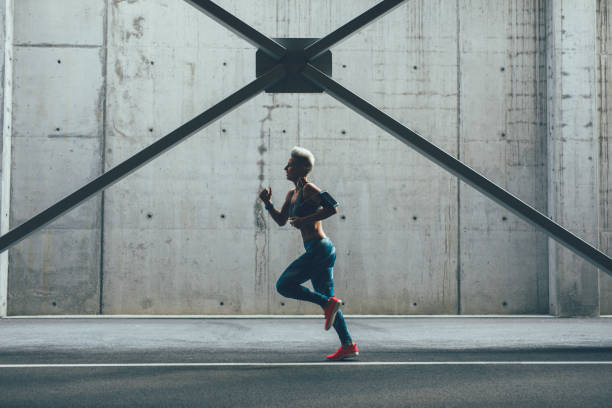 istock Sportswoman running in front of a wall 856931098