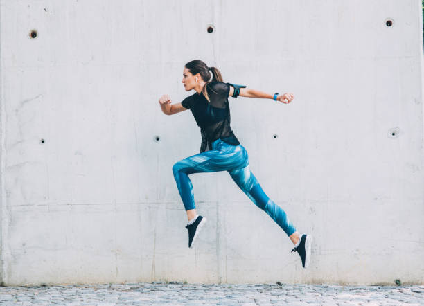 adeptes des activités - jumping women running vitality photos et images de collection